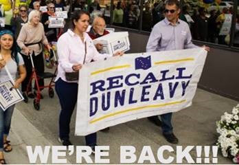 Petitioners marching with banner delcaring 'Recall Dunleavy'