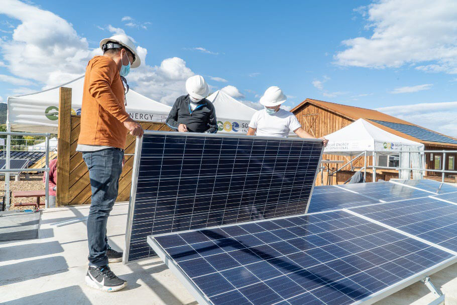 Workers installing solar panels during a training program.
